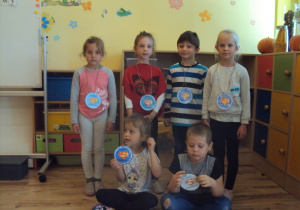 Chłopcy i dziewczynki prezentują swoje medale "Super chłopaka"